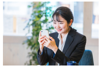 スマートフォンを見て喜ぶ女性